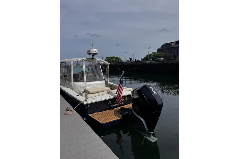 Slide: The Image of 2020 Hunt Yachts Harrier 26 docked, featuring a Mercury outboard motor and American flag. - 36