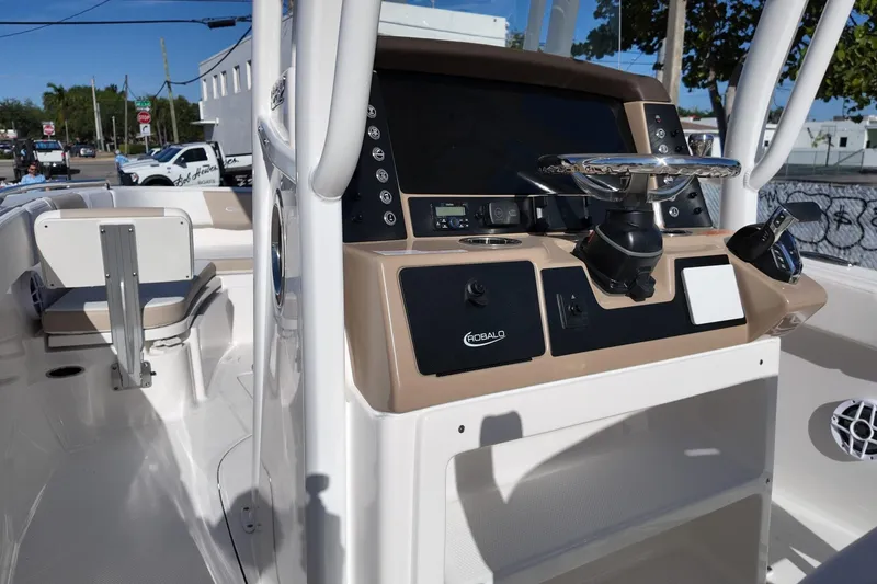 Slide: The Image of 2025 Robalo R232 Explorer boat dashboard with steering wheel and controls. - 13