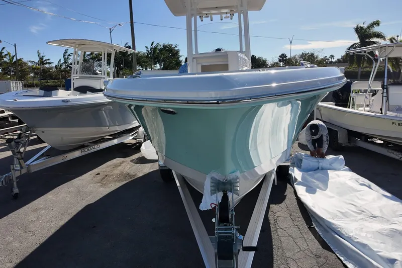 Slide: The Image of 2025 Robalo R232 Explorer boat on trailer, outdoor setting, clear sky. - 2