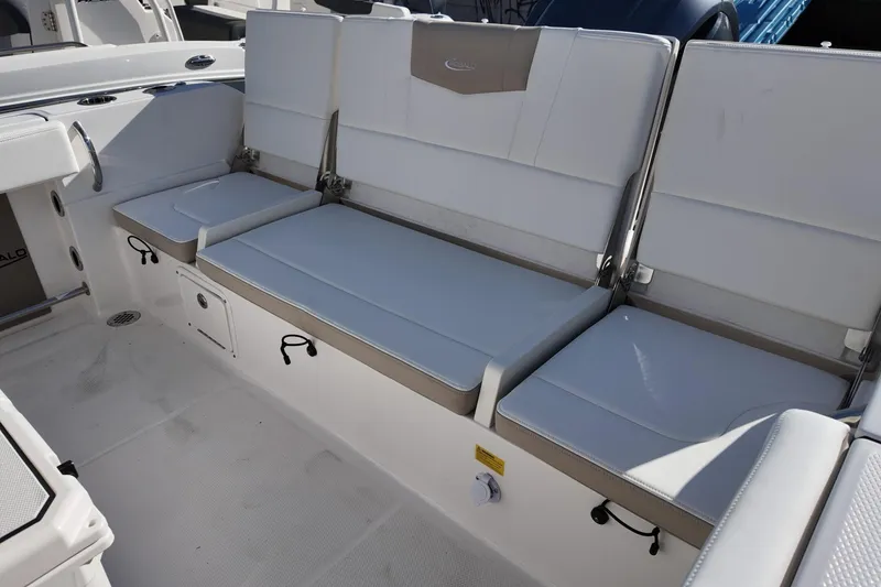Slide: The Image of 2025 Robalo R232 Explorer boat seating area with white cushioned seats. - 7
