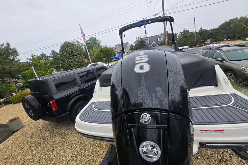 Slide: The Image of 2020 Bayliner VR6 Bowrider OB with Mercury 150 engine, parked beside a black SUV. - 9