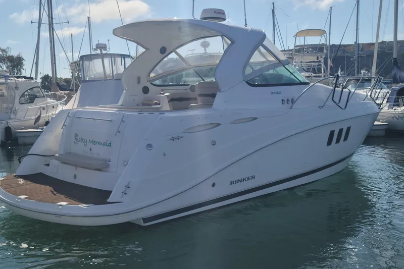 Slide: The Image of 2017 Rinker EX 370 yacht docked in a marina, surrounded by other boats. - 1