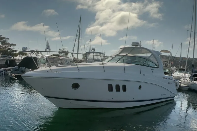 Slide: The Image of 2017 Rinker EX 370 boat interior with seating and table, docked at a marina. - 7
