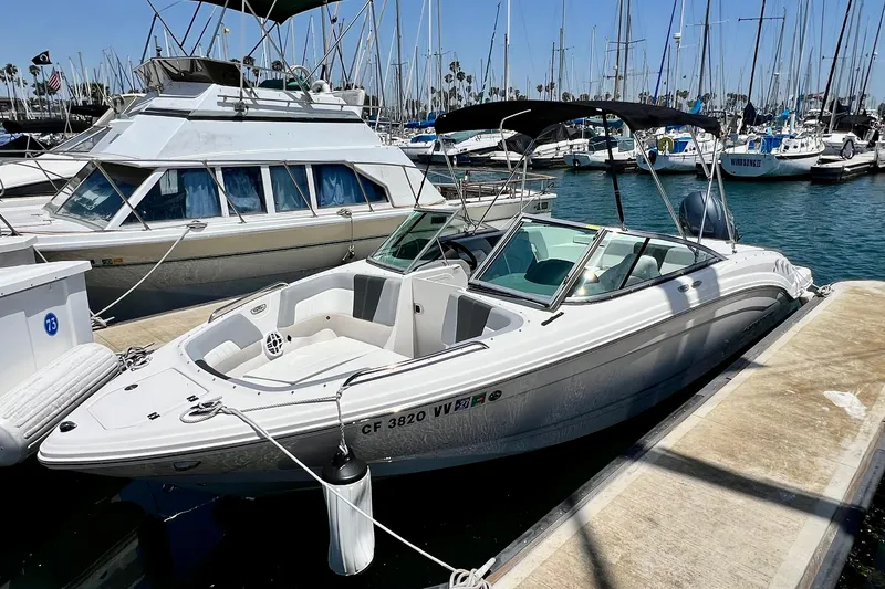 The Image of 2022 Chaparral 230 SSi boat docked at a marina with other vessels. - 0