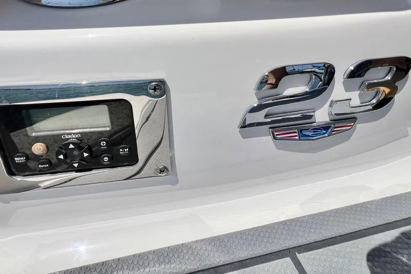Slide: The Image of 2022 Chaparral 230 SSi boat dashboard with Clarion audio system and chrome "23" emblem. - 14