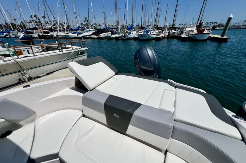 Slide: The Image of 2022 Chaparral 230 SSi boat docked in marina with sailboats in background. - 15