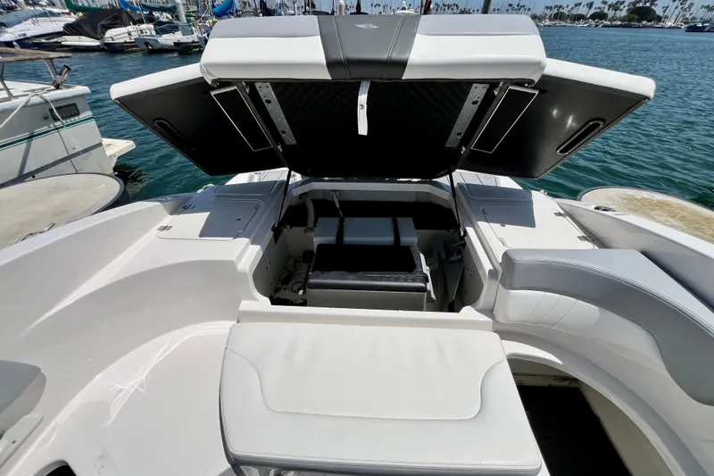 Slide: The Image of 2022 Chaparral 230 SSi boat interior with open storage compartments at marina. - 19
