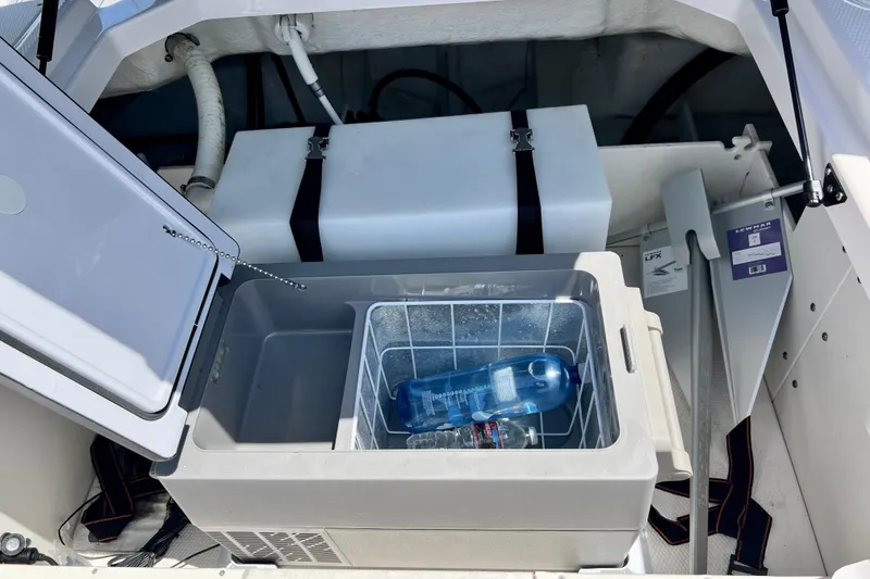 Slide: The Image of Storage compartment of 2022 Chaparral 230 SSi boat with cooler and water bottles. - 20