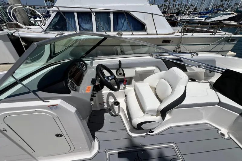 Slide: The Image of 2022 Chaparral 230 SSi boat interior with white seating and steering wheel. - 24