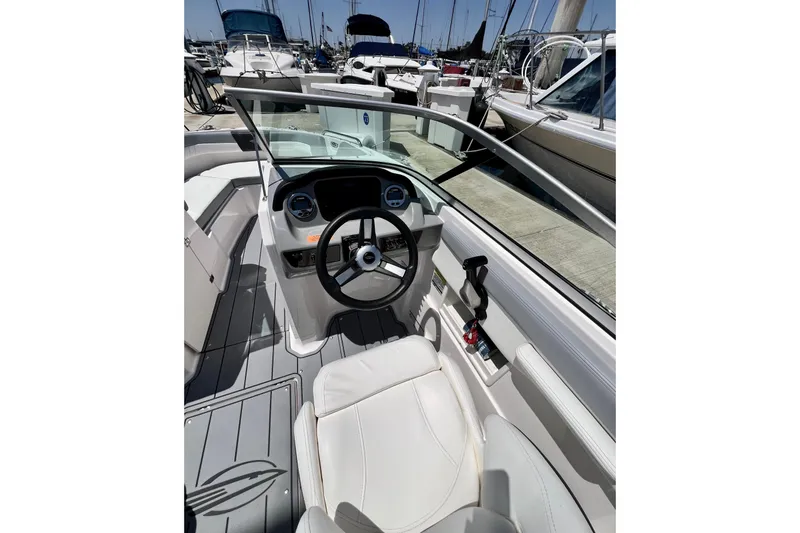 Slide: The Image of Interior view of 2022 Chaparral 230 SSi boat cockpit with steering wheel and seating. - 25