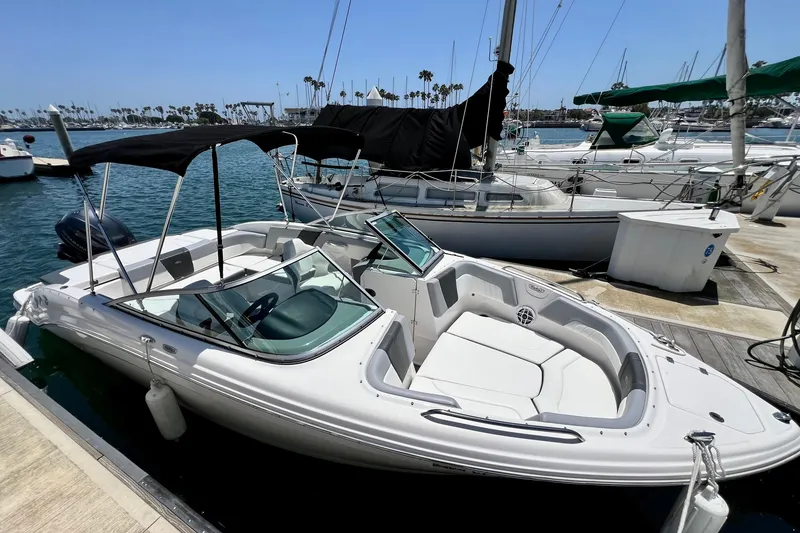 Slide: The Image of 2022 Chaparral 230 SSi boat docked at marina, featuring sleek design and spacious seating. - 3