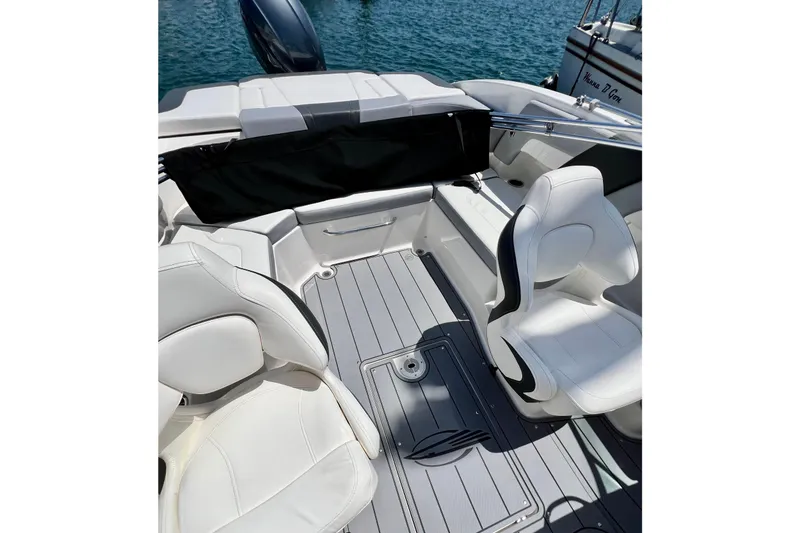 Slide: The Image of 2022 Chaparral 230 SSi boat interior with white seating and sleek design on water. - 31