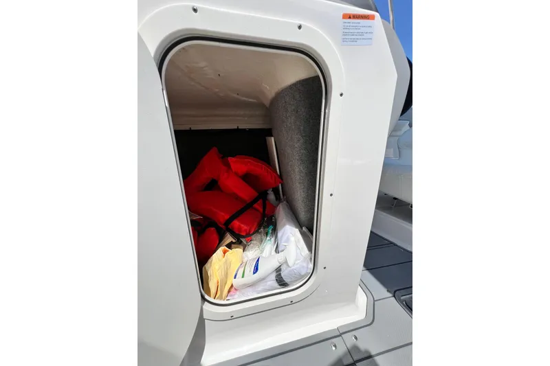 Slide: The Image of Storage compartment on 2022 Chaparral 230 SSi boat with life jackets and supplies. - 37