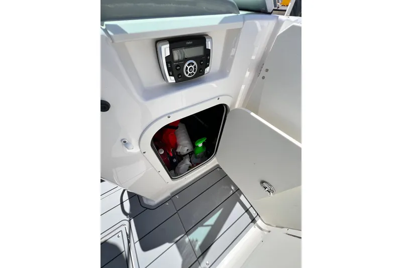 Slide: The Image of 2022 Chaparral 230 SSi boat interior storage compartment with open door and visible equipment. - 38