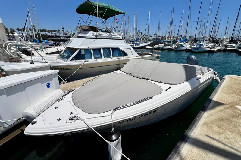 Slide: The Image of 2022 Chaparral 230 SSi boat docked in a marina with sailboats in the background. - 4