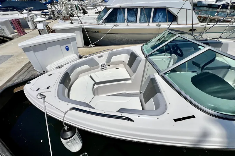 Slide: The Image of 2022 Chaparral 230 SSi boat docked, featuring spacious seating and sleek design. - 5