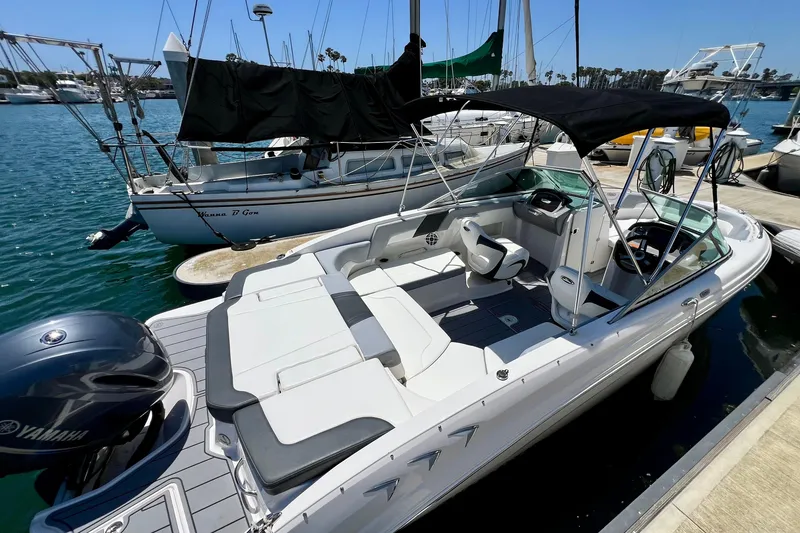 Slide: The Image of 2022 Chaparral 230 SSi boat docked in marina, featuring sleek design and Yamaha engine. - 6