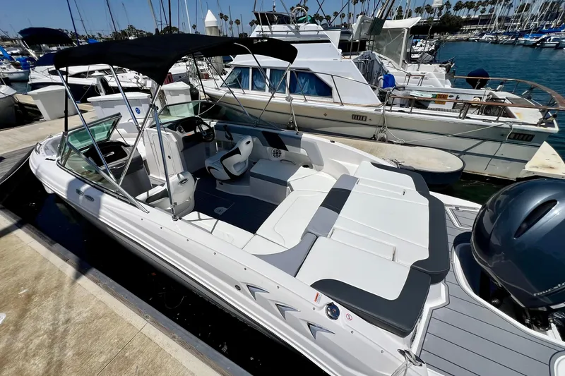 Slide: The Image of 2022 Chaparral 230 SSi boat docked at marina, featuring sleek design and spacious seating. - 7