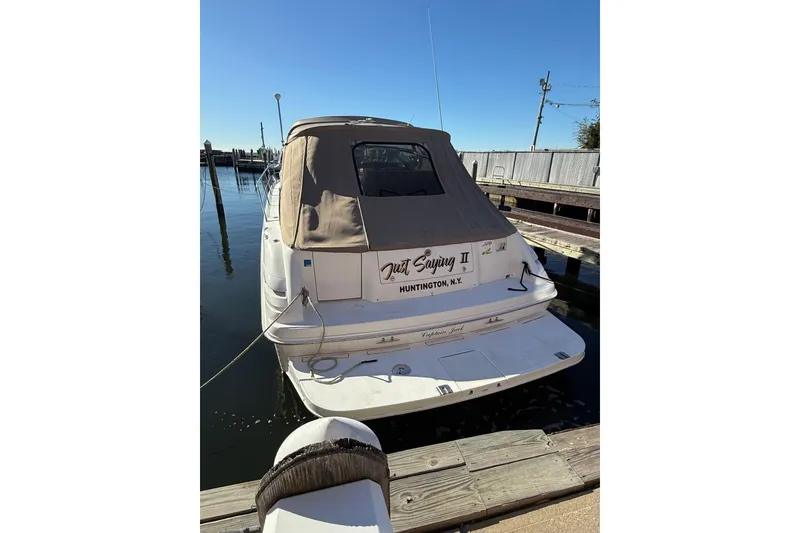 Slide: The Image of 1997 Sea Ray Sundancer 370 docked at marina, rear view with covered cabin. - 10