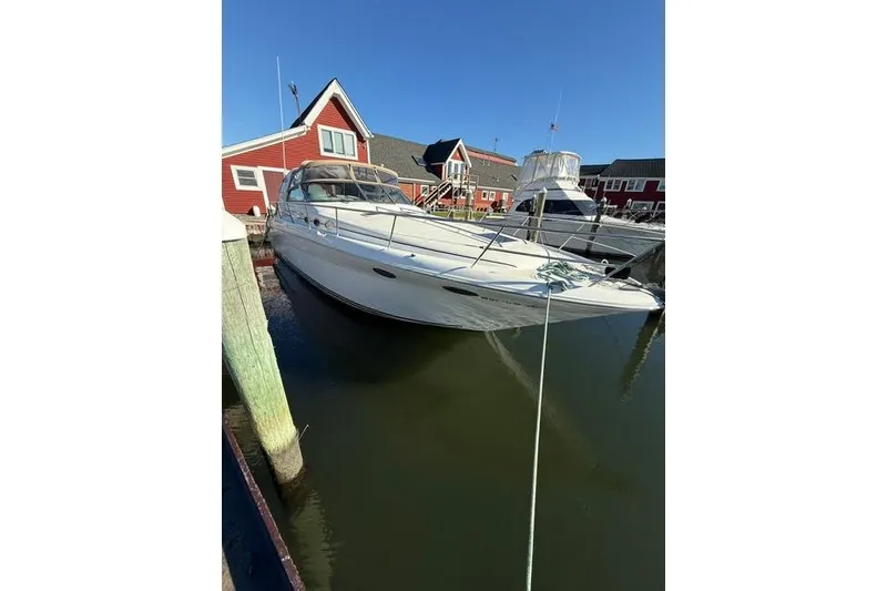 Slide: The Image of 1997 Sea Ray Sundancer 370 docked near red buildings under clear blue sky. - 13