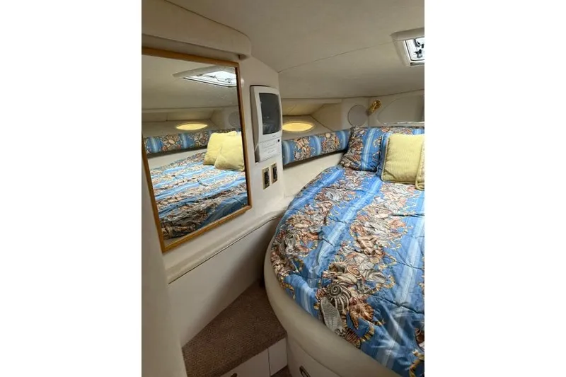 Slide: The Image of Cozy cabin interior of 1997 Sea Ray Sundancer 370 with patterned bedding and mirror. - 14