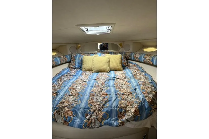 Slide: The Image of Cozy cabin interior of 1997 Sea Ray Sundancer 370 with patterned bedding and pillows. - 2
