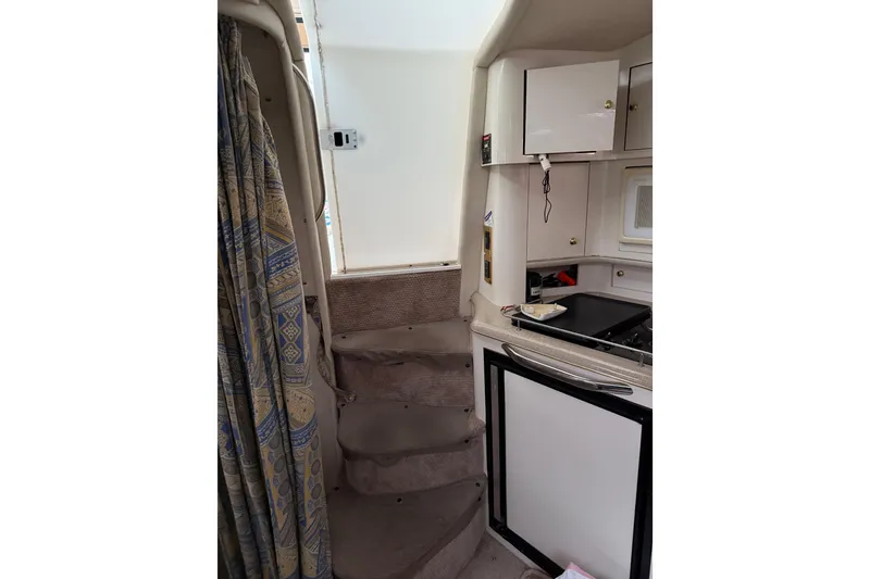 Slide: The Image of Interior of 1997 Sea Ray Sundancer 370, featuring compact kitchen and carpeted stairs. - 22