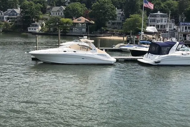 Slide: The Image of 1997 Sea Ray Sundancer 370 docked at a marina with waterfront homes in the background. - 5