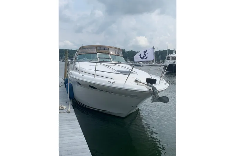 Slide: The Image of 1997 Sea Ray Sundancer 370 docked, featuring sleek design and nautical flag. - 8