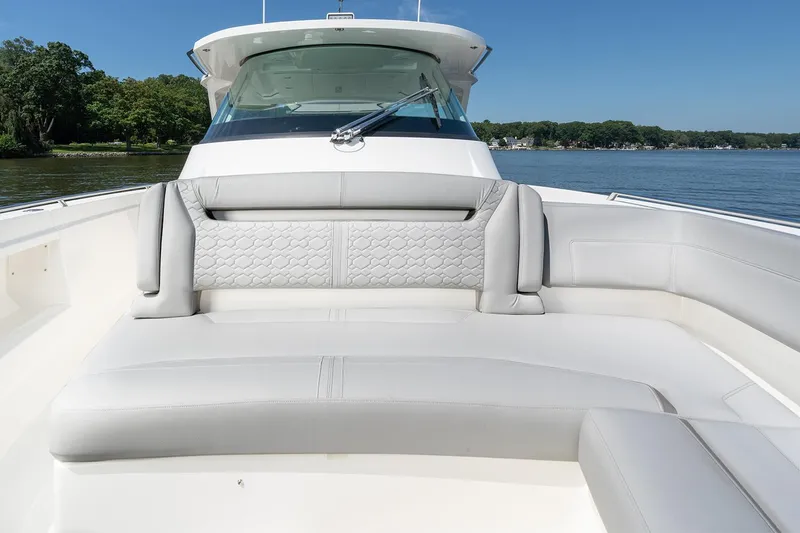 Slide: The Image of Manufacturer Provided Image: 2025 Tiara Yachts 38 LS boat with luxurious seating on a calm lake. - 16