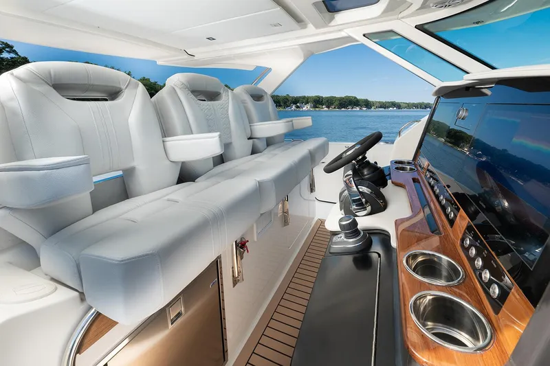 Slide: The Image of Manufacturer Provided Image: 2025 Tiara Yachts 38 LS interior with luxurious seating and modern dashboard on a serene lake. - 17