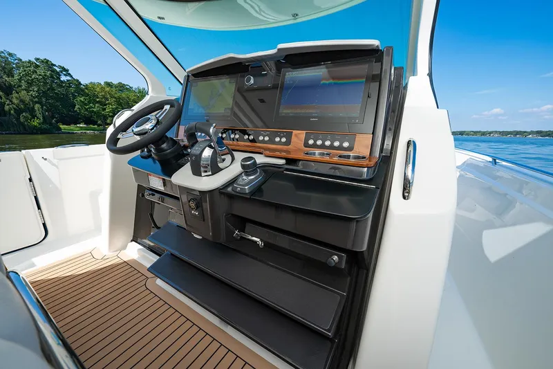 Slide: The Image of Manufacturer Provided Image: 2025 Tiara Yachts 38 LS helm with modern controls and dual screens, overlooking serene waters. - 18