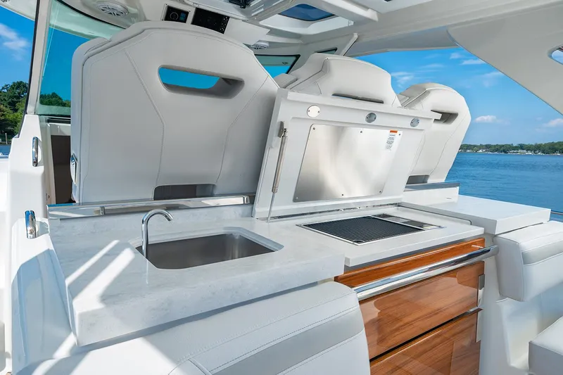 Slide: The Image of Manufacturer Provided Image: 2025 Tiara Yachts 38 LS interior with sleek kitchen and seating, overlooking serene water. - 19