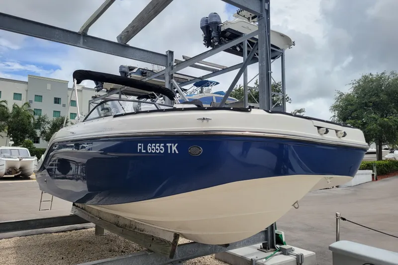The Image of 2023 Bayliner DX 2200 boat in dry dock, blue and white hull, registration FL 6555 TK. - 1