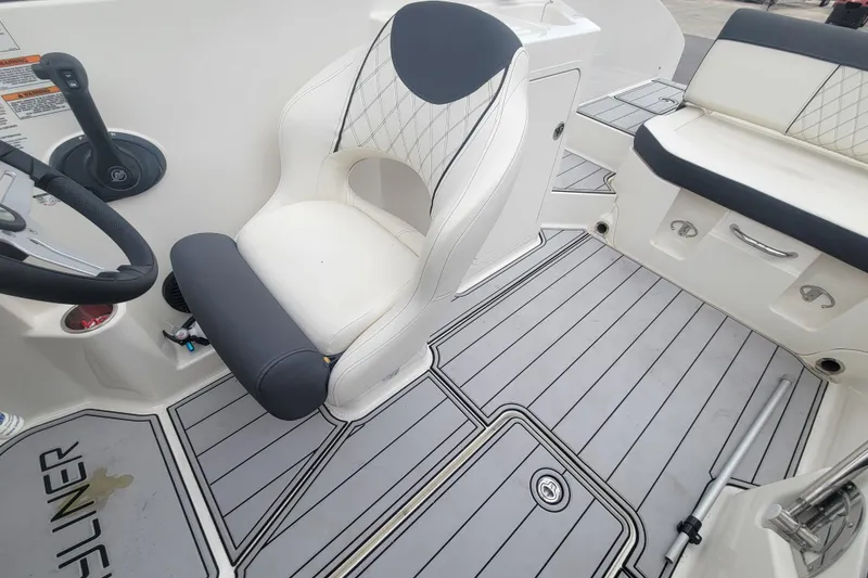 Slide: The Image of 2023 Bayliner DX 2200 boat interior with white seating and gray flooring. - 13