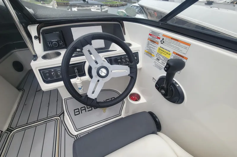 Slide: The Image of 2023 Bayliner DX 2200 boat cockpit with steering wheel and control panel. - 6