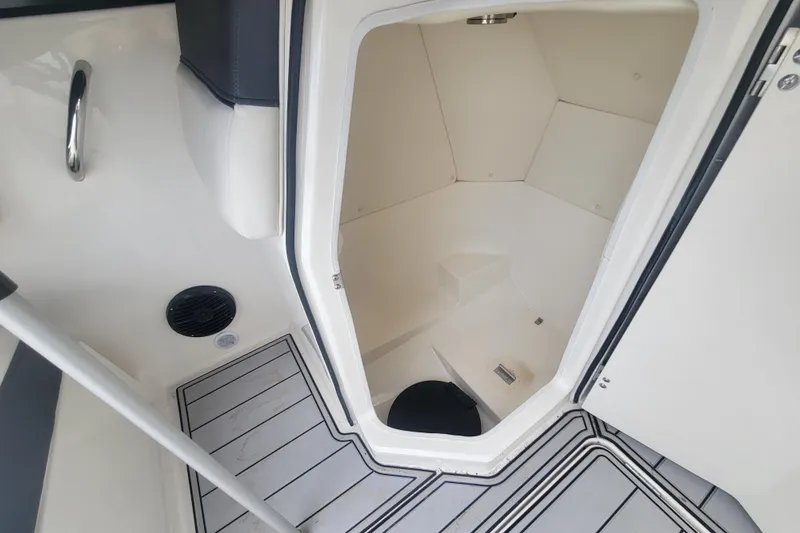 Slide: The Image of 2023 Bayliner DX 2200 boat interior with open storage compartment and sleek flooring. - 9