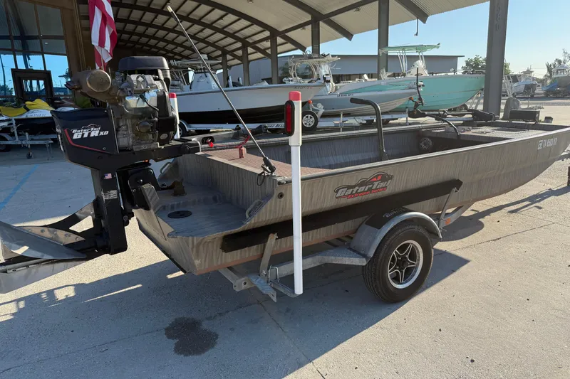 Slide: The Image of 2023 Gator Tail 1852 boat on trailer, parked under a canopy. - 3