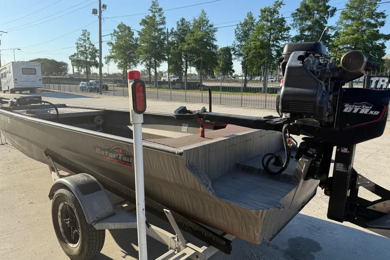 Slide: The Image of 2023 Gator Tail 1852 boat on trailer with outboard motor, parked outdoors. - 5