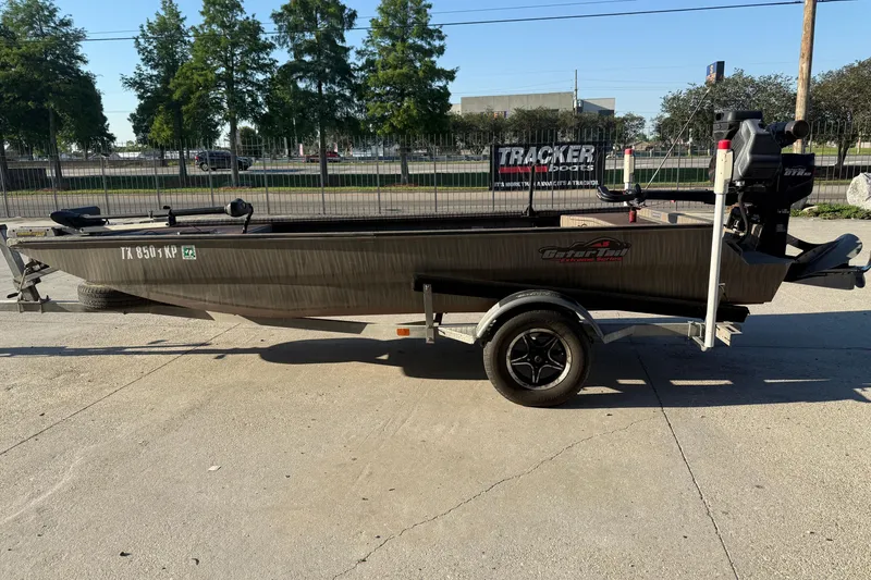 Slide: The Image of 2023 Gator Tail 1852 boat on trailer, parked outdoors in sunny setting. - 6