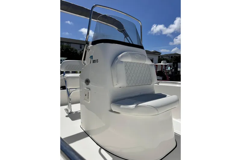 Slide: The Image of 2026 Key West 189 FS boat interior with cushioned seating and console under clear blue sky. - 20
