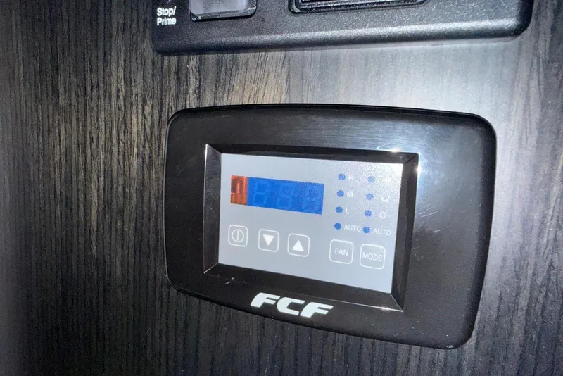 Slide: The Image of Control panel on Schaefer 400 Sport 2023 boat, featuring digital display and buttons. - 14
