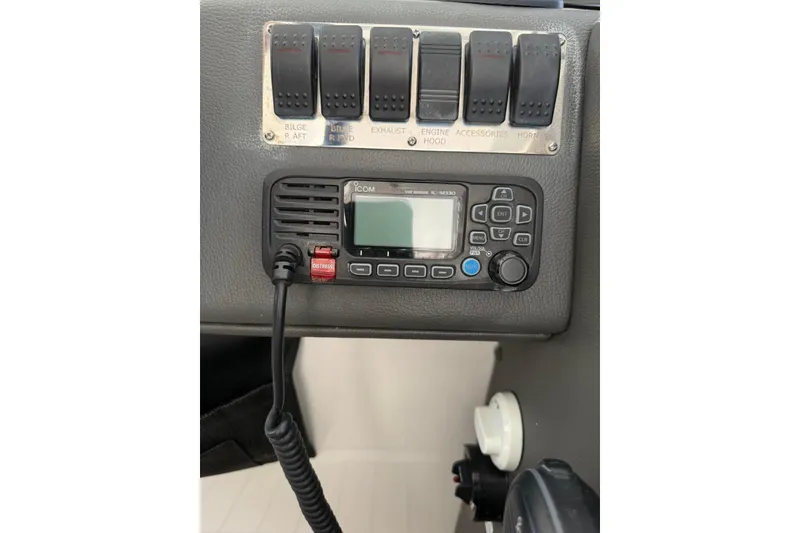 Slide: The Image of Control panel of 2023 Schaefer 400 Sport with marine radio and switches. - 17