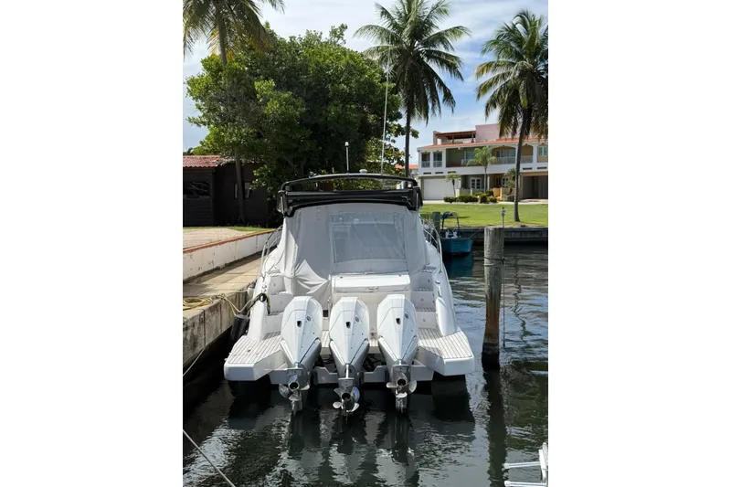 Slide: The Image of 2023 Schaefer 400 Sport yacht docked, featuring triple outboard engines, surrounded by palm trees. - 2