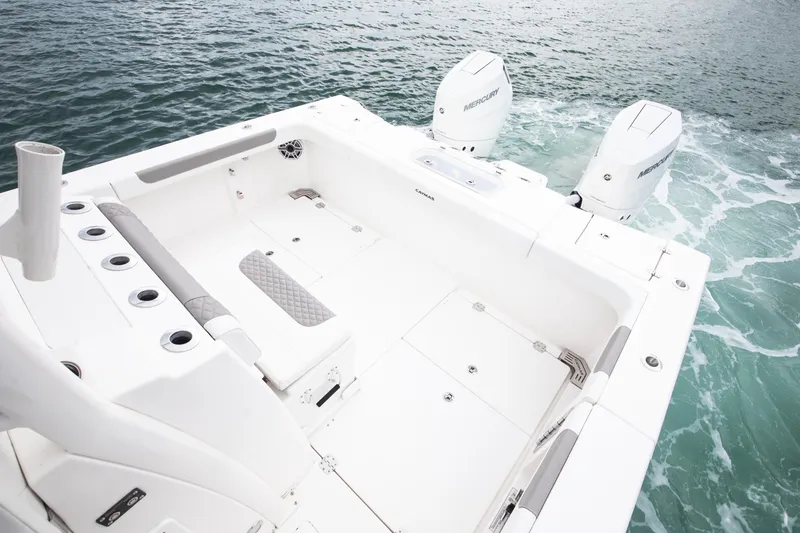 Slide: The Image of 2024 Caymas 341 CC boat deck with dual Mercury engines on open water. - 12
