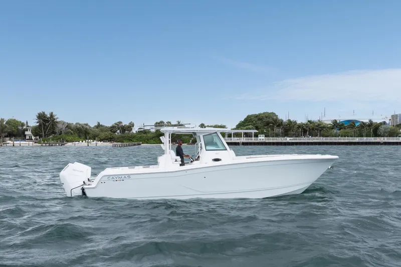 Slide: The Image of 2024 Caymas 341 CC boat cruising on a sunny day near a lush shoreline. - 16