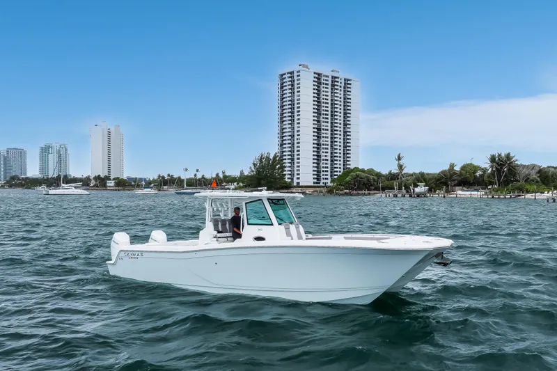 Slide: The Image of 2024 Caymas 341 CC boat cruising on water with city skyline in background. - 3