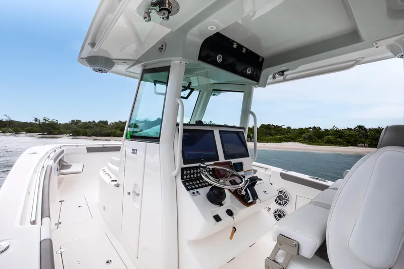 Slide: The Image of 2024 Caymas 341 CC boat interior with advanced navigation system, near scenic shoreline. - 6