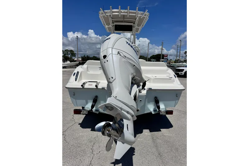Slide: The Image of 2026 Key West 219 FS boat with Yamaha outboard motor, parked on pavement. - 10