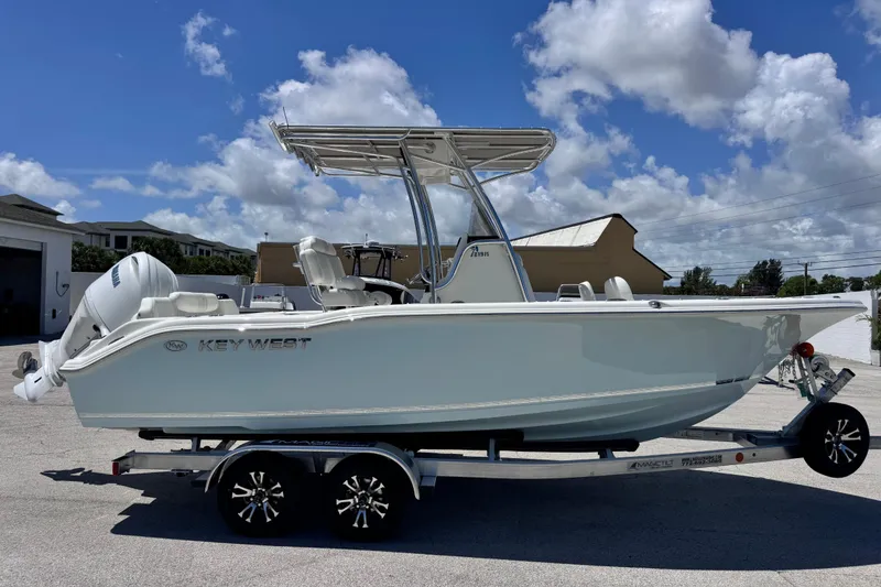 Slide: The Image of 2026 Key West 219 FS boat on trailer under clear blue sky. - 11